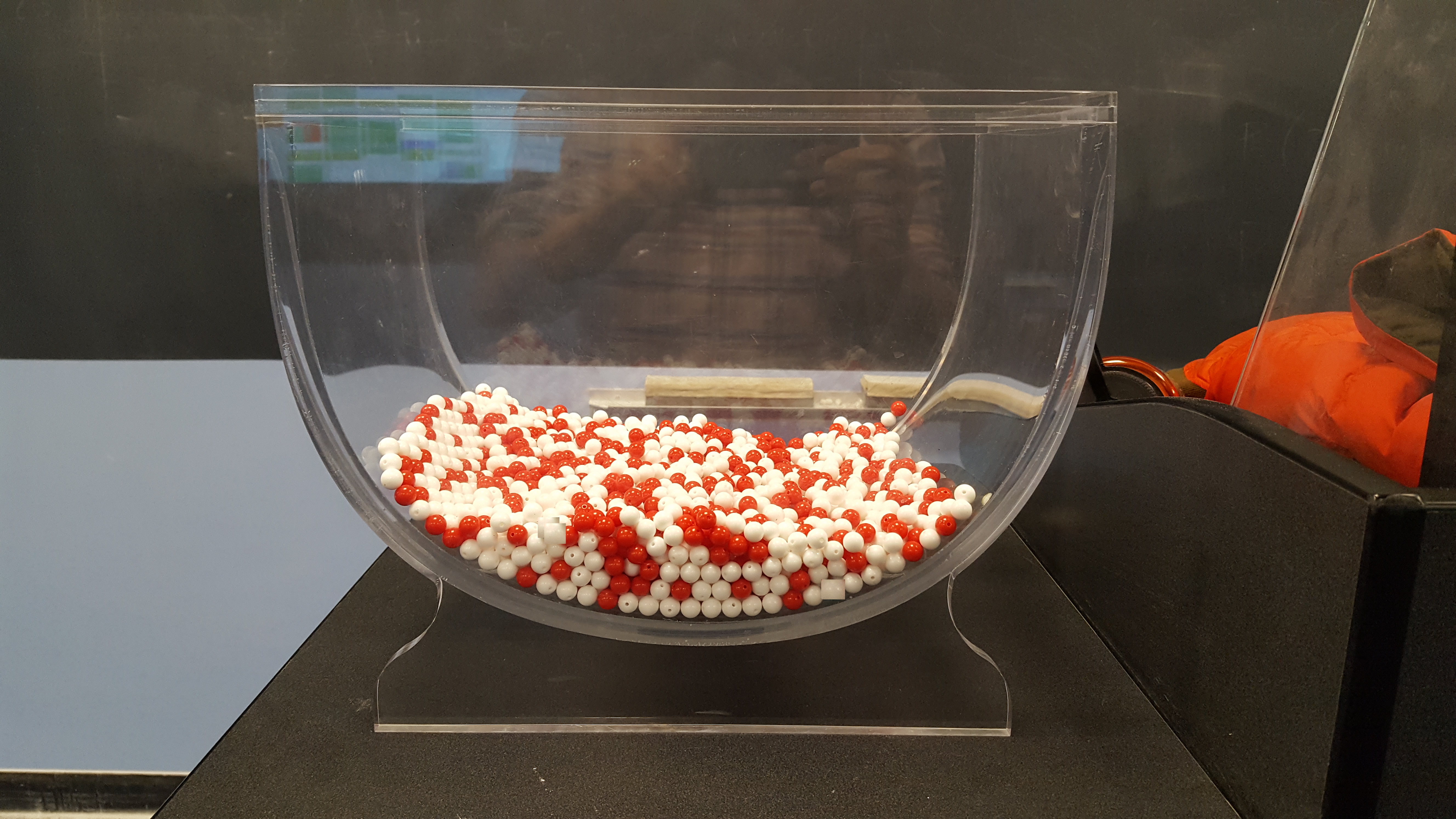 A large bowl containing a mixture of red and white balls.